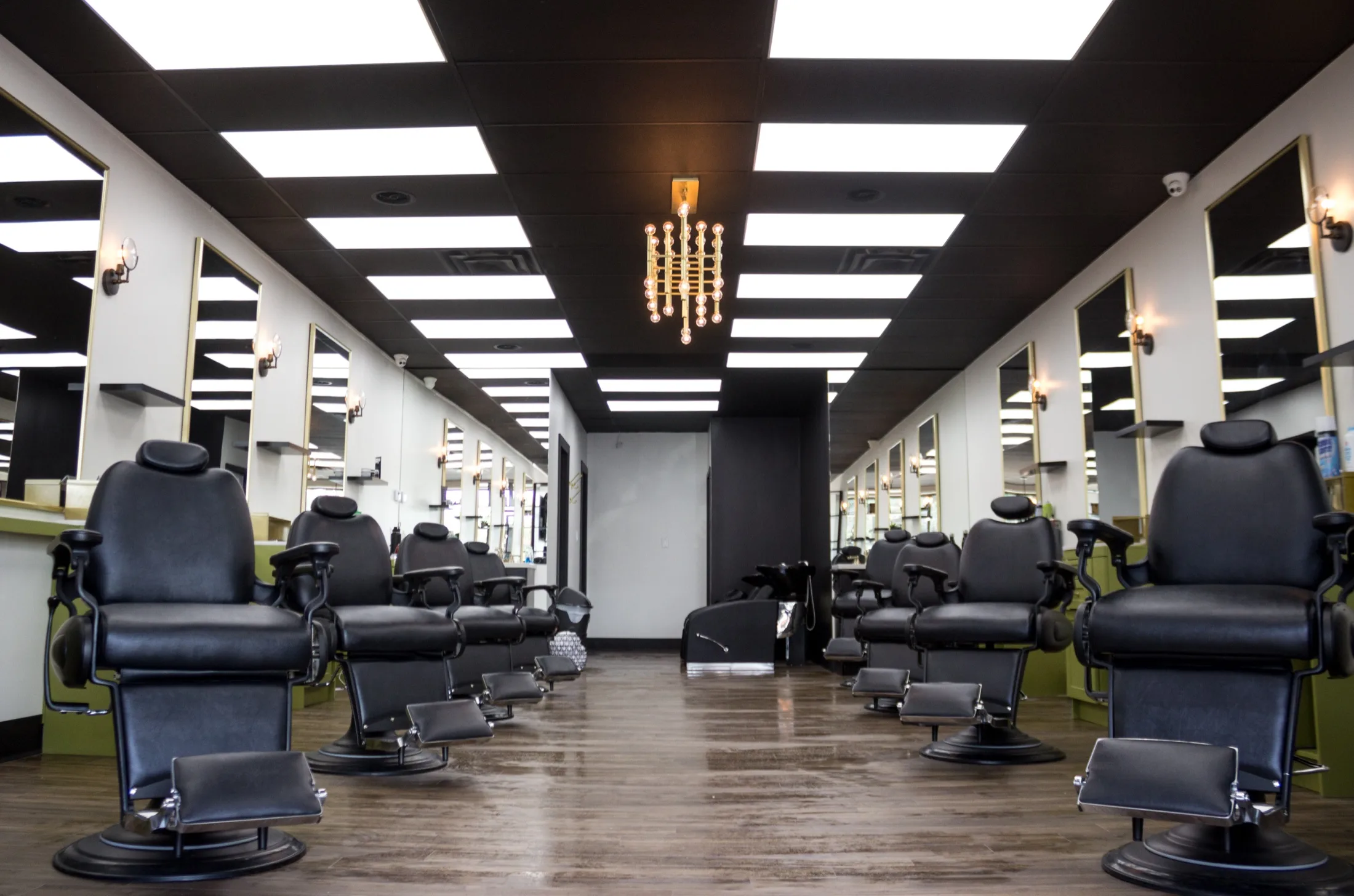 Chair barbershop interior, Toronto, eight chairs symmetric with gold chandelier